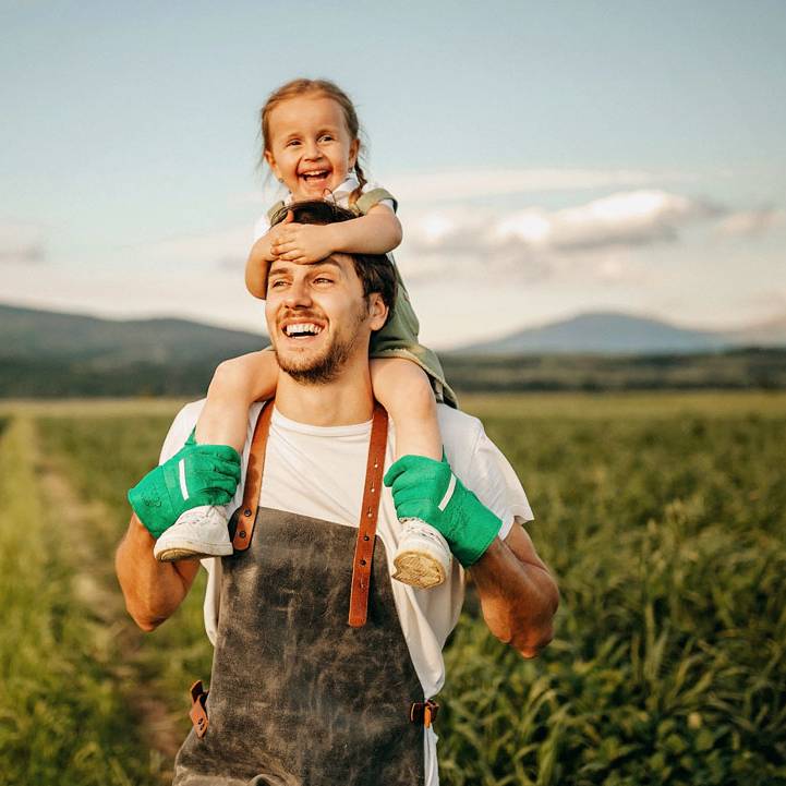 Father carrying his daughter on the famr land